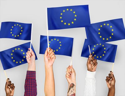 En masse EU-flag der holdes af hænder i alle farver